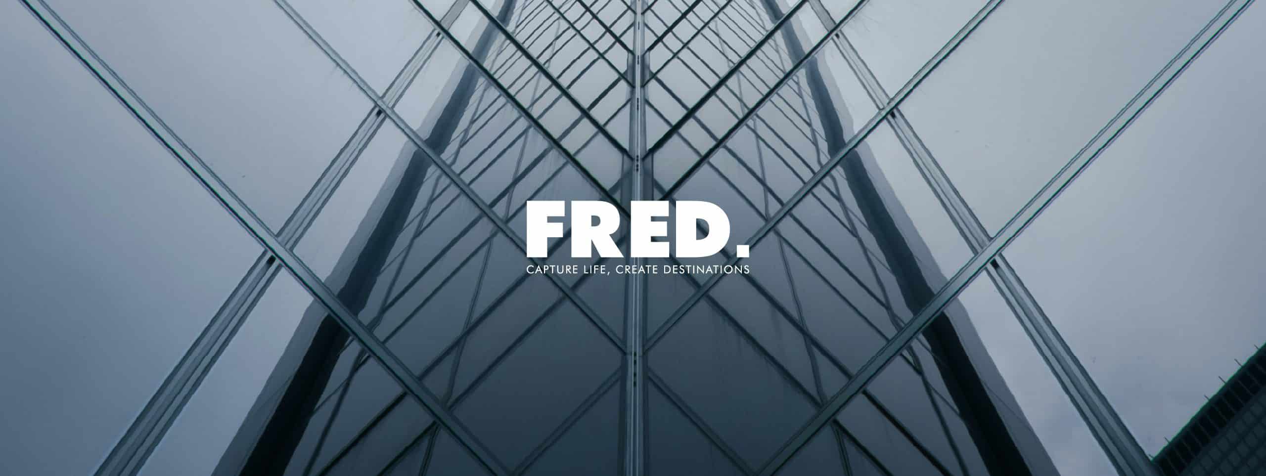 Glazen gevel van een toren, met het logo van FRED Developers