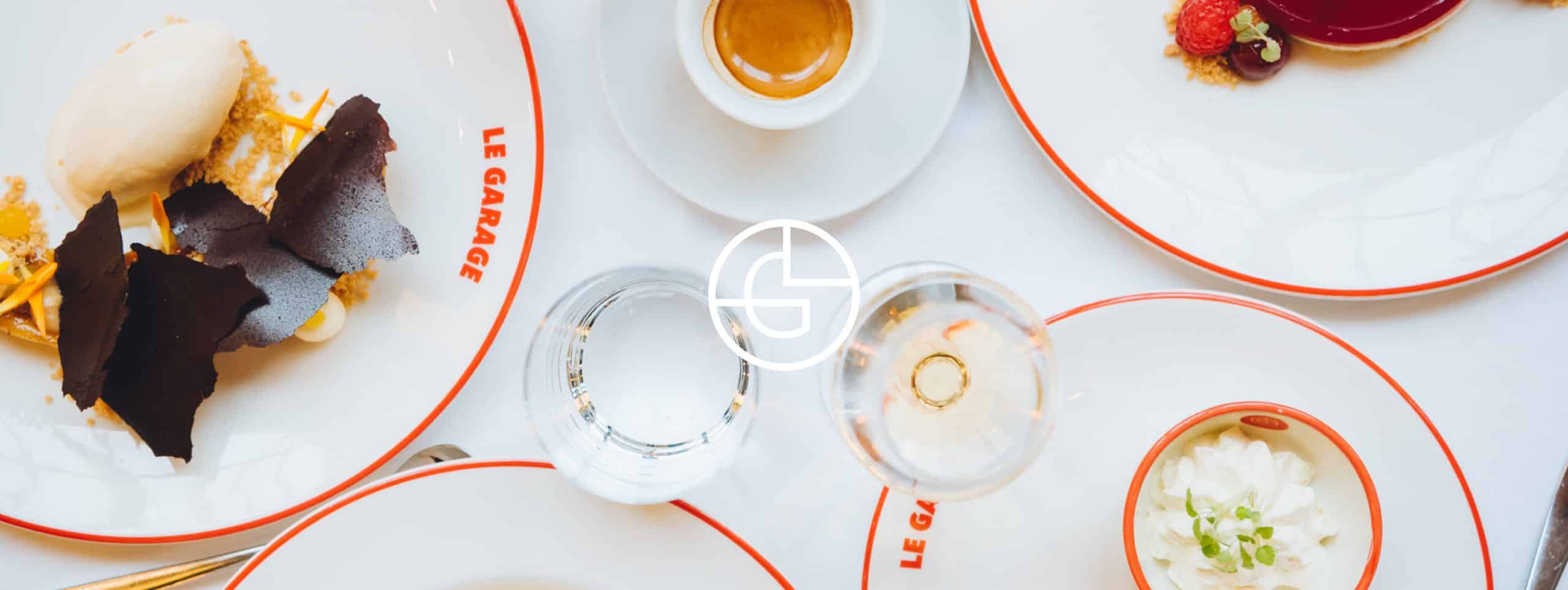 Desserts en koffie op borden met het logo van Le Garage