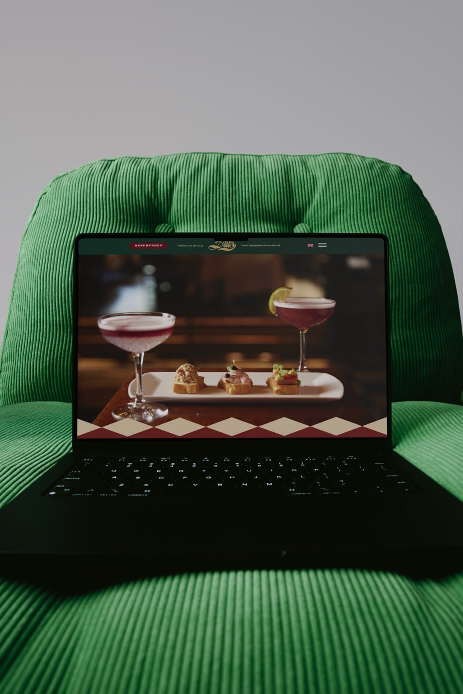 Website van Restaurant Old Dutch op een laptop in een groene stoel